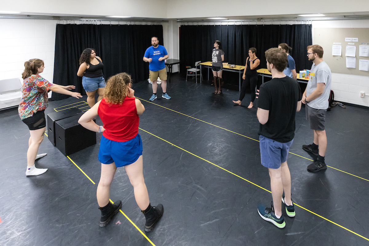 Students in a theatre classroom standing in circle